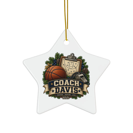 A white star-shaped Christmas ornament with a gold hanging string, featuring a custom basketball-themed graphic that reads 'COACH DAVIS' with a basketball, clipboard, whistle, pinecones, and evergreen branches.