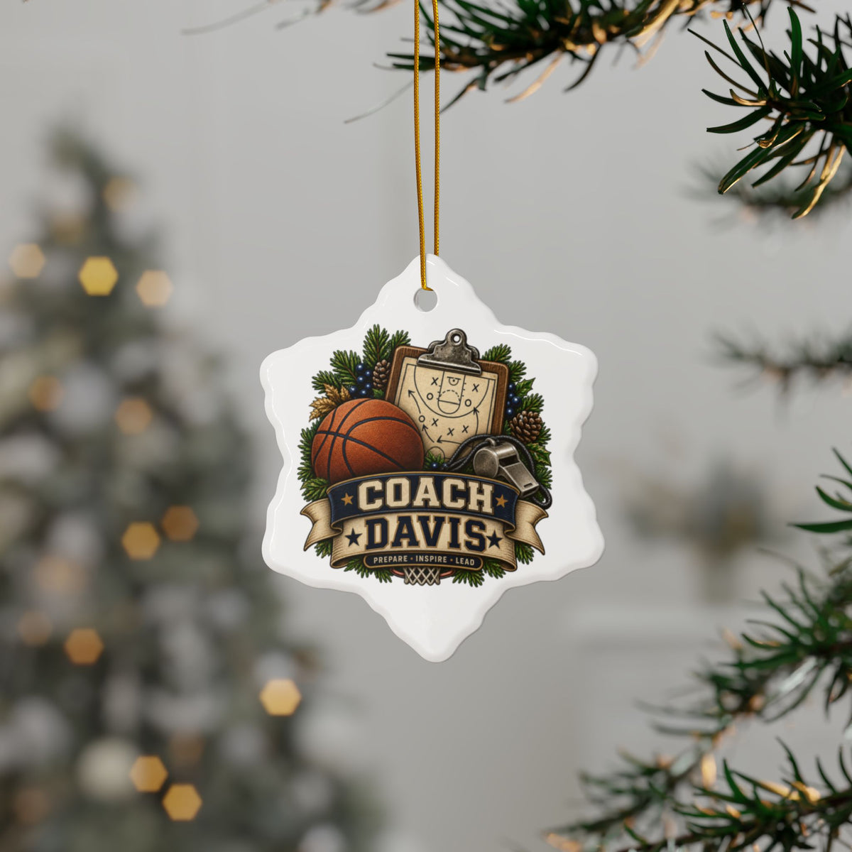 A white snowflake-shaped Christmas ornament hanging from a gold string on a Christmas tree branch. The ornament features a basketball court graphic, a basketball, a whistle, pine branches, and a banner reading 'COACH DAVIS'.