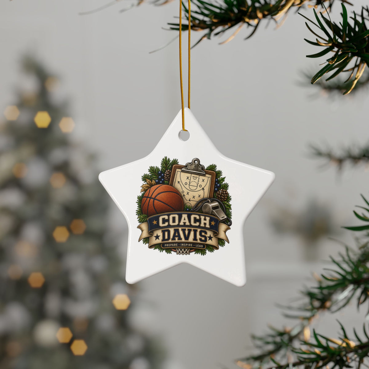 A white star-shaped Christmas ornament hanging from a gold string on a Christmas tree branch. The ornament features a custom sports graphic with the text 'COACH DAVIS' and an illustration of a basketball, clipboard, and trophy.